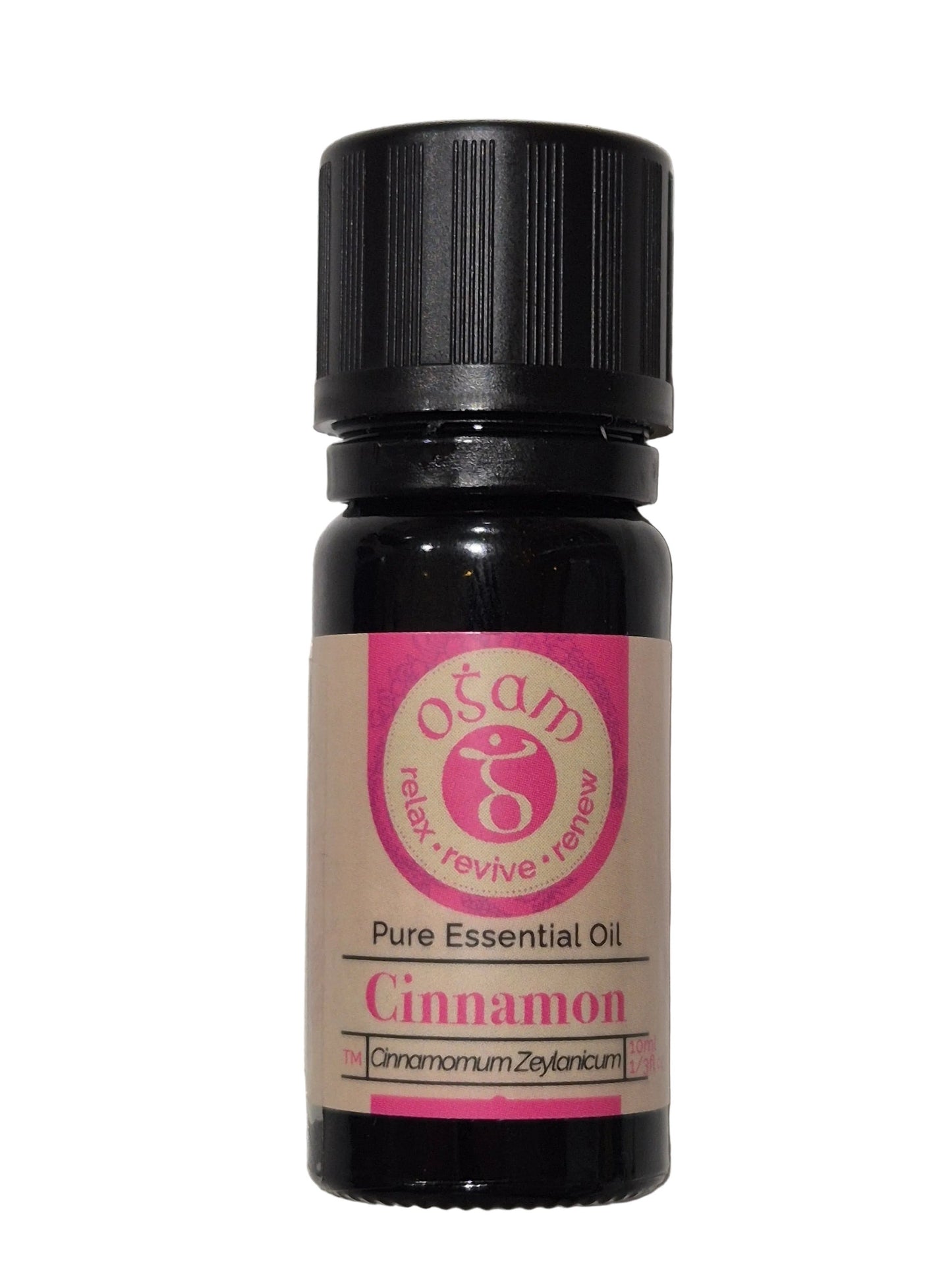 A small essential oil bottle labeled 'Ocean Organic Cinnamon Pure Essential Oil' with a black cap and a pink and beige label, resting on a textured white surface.